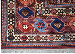 Handwoven Afghan Herati rug featuring a geometric pattern in blue, red, and purple wool.