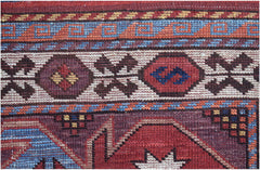 A close-up of an Afghan Herati rug featuring intricate geometric patterns in red, blue, and cream.