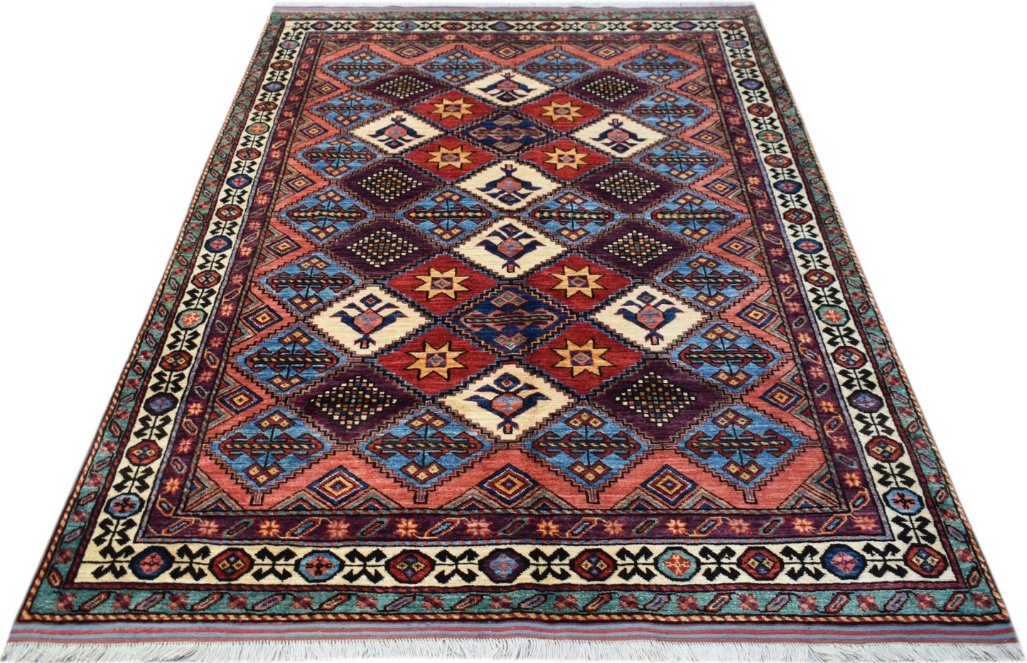 A handwoven Afghan Herati rug featuring a geometric diamond pattern in red, blue, and cream tones.