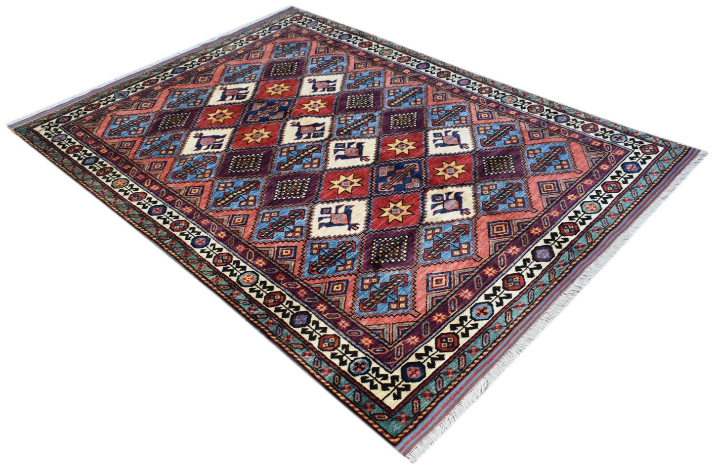 An Afghan Herati rug featuring a geometric diamond pattern in red, blue, and cream wool.
