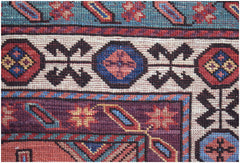 A close-up of an Afghan Herati rug featuring intricate geometric patterns in red, blue, and cream.