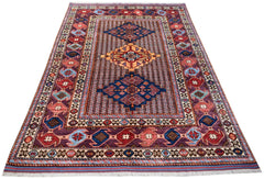 Handwoven Afghan Herati rug featuring a geometric pattern in shades of red, blue, and gold.