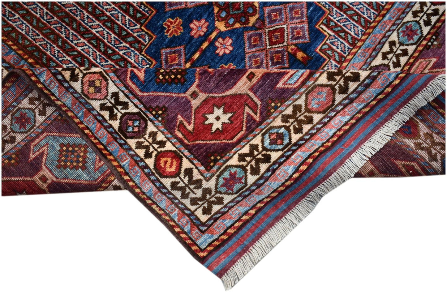 A handwoven Afghan Herati rug featuring intricate geometric patterns in blue, red, and purple.