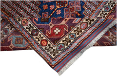 A handwoven Afghan Herati rug featuring intricate geometric patterns in blue, red, and purple.