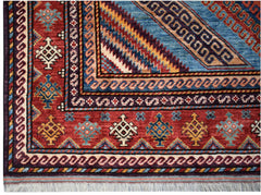 A handwoven Afghan Herati rug featuring intricate geometric patterns in red, blue, and gold.