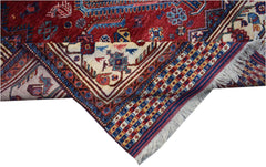 A handwoven Afghan Herati rug featuring a red field with intricate blue and cream geometric motifs.