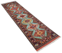A handmade Afghan Herati runner rug featuring a repeating geometric pattern on a teal background.