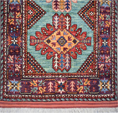 Handwoven Afghan Herati runner featuring a central geometric medallion on a light blue field.