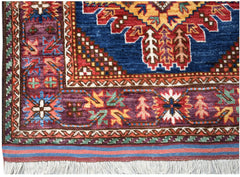 A handwoven Afghan Herati runner featuring a deep blue center with intricate red and gold patterns.