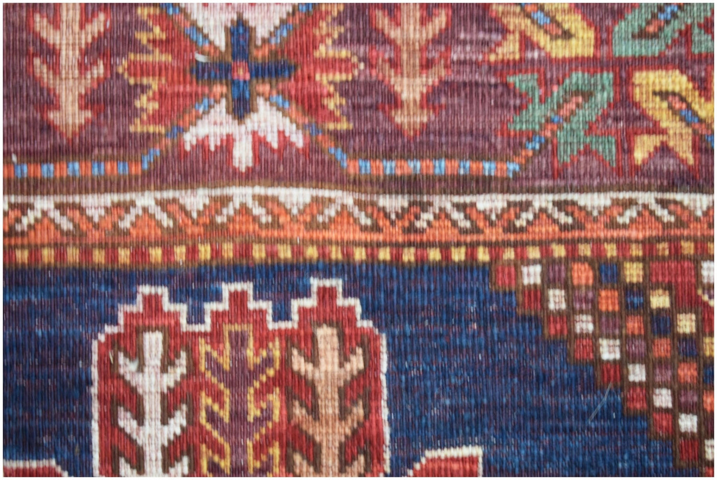 A close-up of an Afghan Herati runner featuring intricate geometric patterns in wool.
