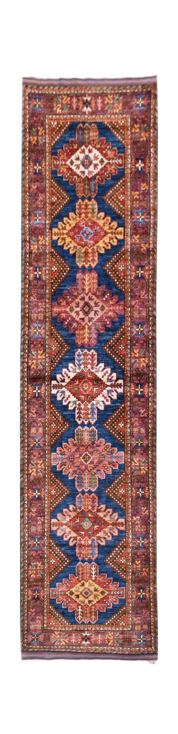 Handwoven Afghan runner rug featuring a blue field with repeating geometric floral medallions.