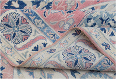 A handmade Afghan Kazakh rug featuring traditional floral motifs in shades of pink, blue, and cream.