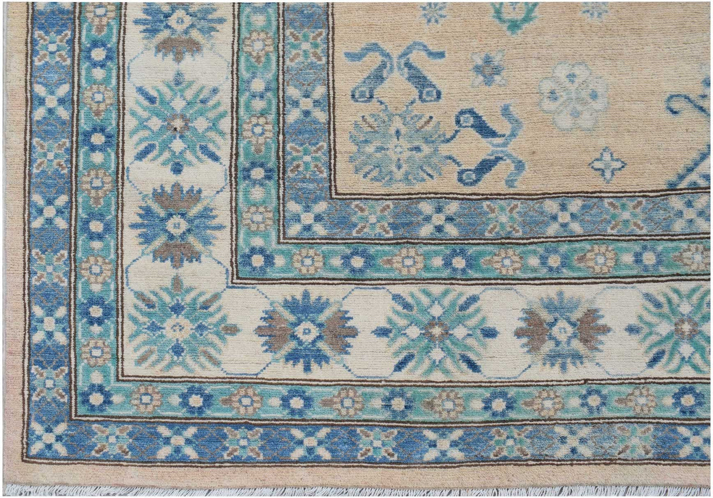 A handmade Afghan Kazakh rug featuring a beige field with blue and grey floral geometric patterns.