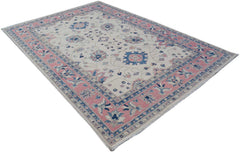An Afghan Kazakh rug featuring traditional floral motifs in blue and pink on a cream background.