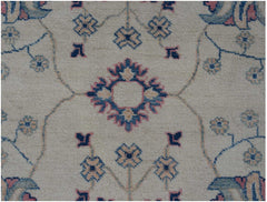 An Afghan Kazakh rug featuring a cream field with traditional blue and pink floral motifs.