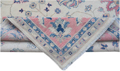 Handmade Afghan Kazakh rug featuring a cream field with blue and pink floral motifs.
