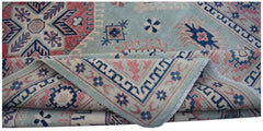 A handmade Afghan Kazakh rug featuring traditional geometric motifs in blue, pink, and cream.