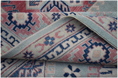 A handmade Afghan Kazakh rug featuring traditional geometric motifs in blue, pink, and cream wool.