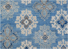Handmade Afghan Kazakh rug featuring a repeating geometric floral pattern in blue, grey, and beige.