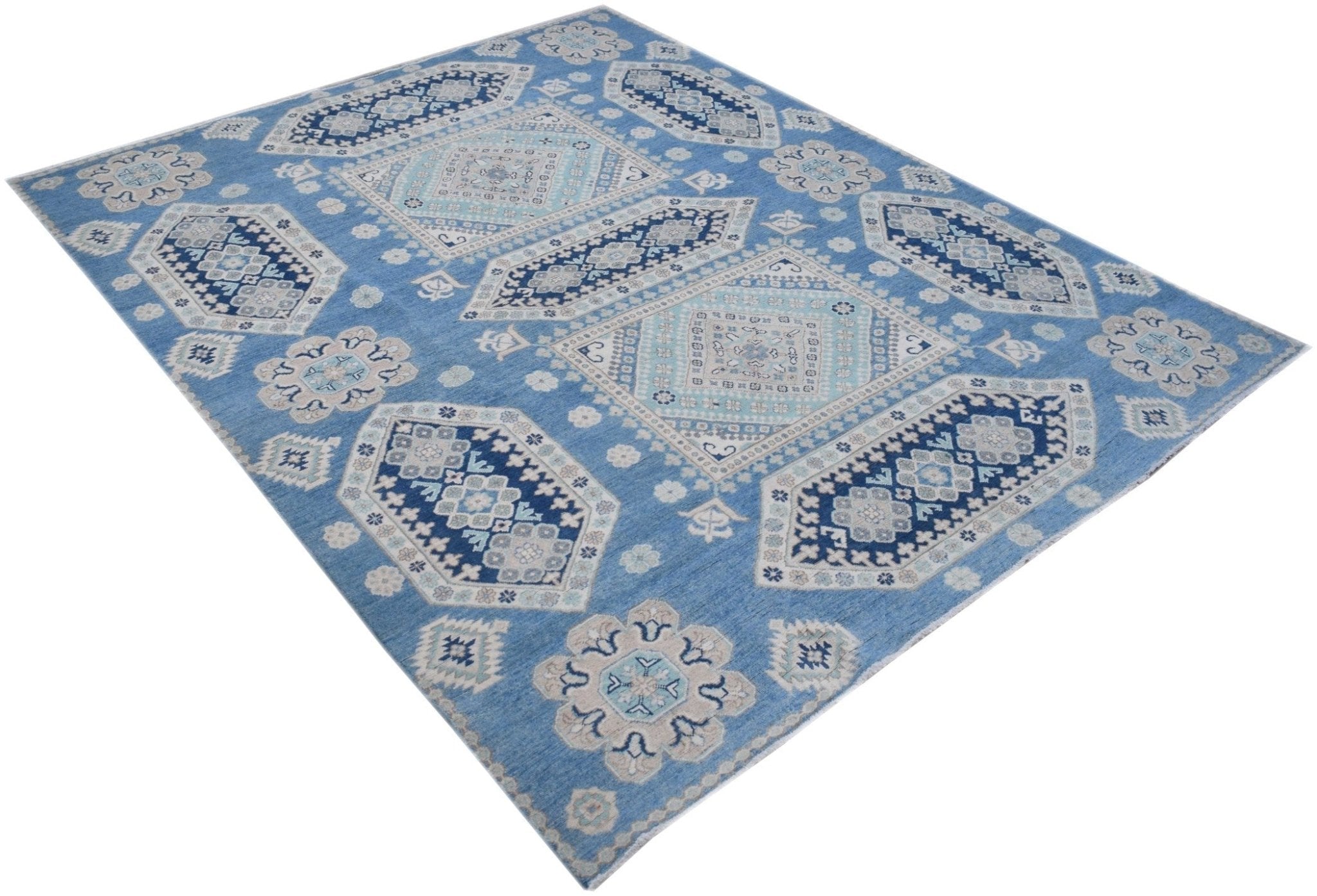 A handmade Afghan Kazakh rug featuring a geometric pattern in shades of blue, beige, and grey.