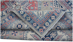 A handmade Afghan Kazakh rug featuring traditional geometric motifs in blue, red, and beige wool.