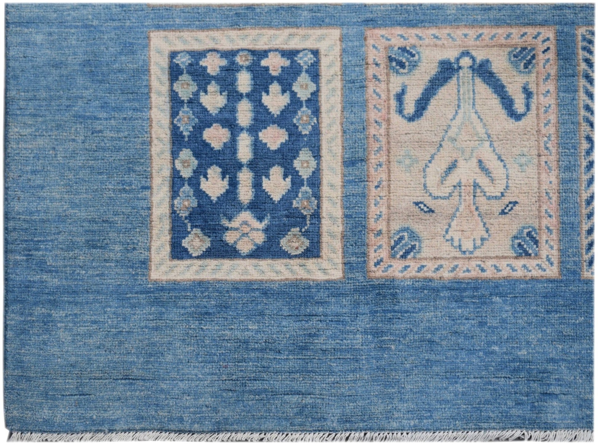 Handmade Afghan Kazakh rug featuring blue and beige rectangular motifs on a blue wool field.