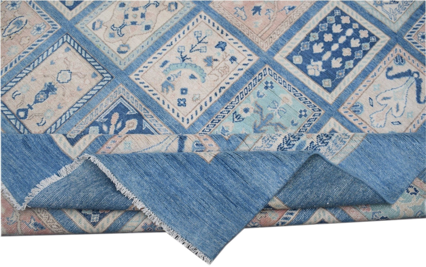 An Afghan Kazakh rug featuring a geometric patchwork design in shades of blue, beige, and grey.