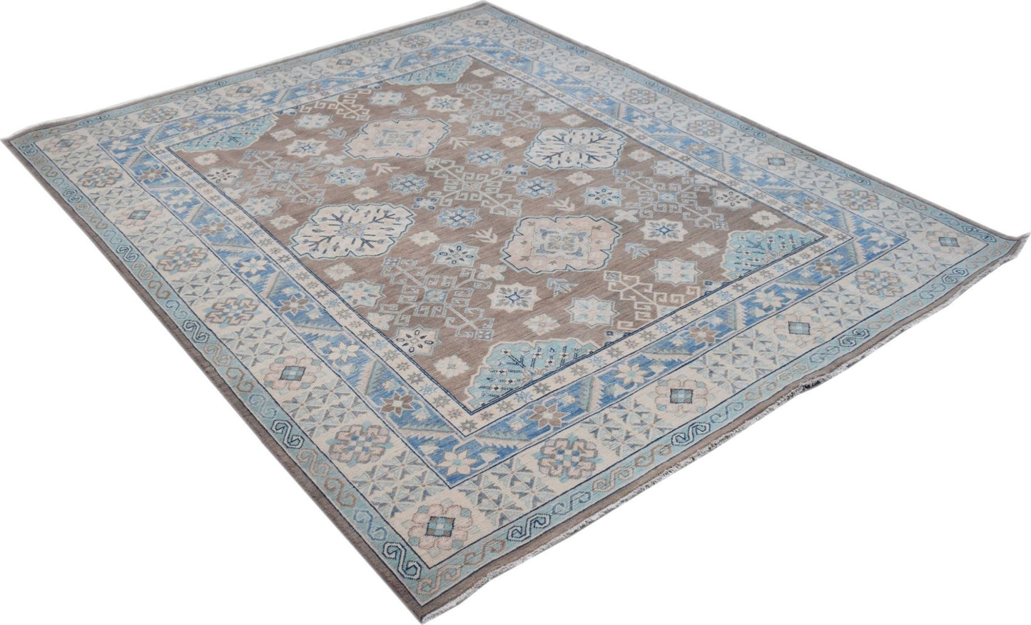 A handmade Afghan Kazakh rug featuring a geometric pattern in shades of beige, blue, and grey.