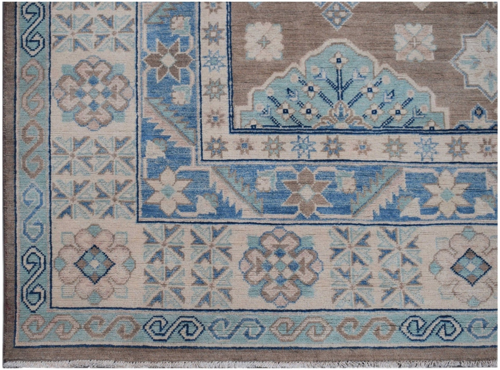 Handmade Afghan Kazakh rug featuring geometric floral patterns in shades of blue, beige, and grey.