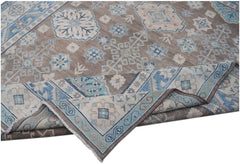 An Afghan Kazakh rug featuring a geometric pattern in shades of beige, blue, and grey.