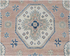 Handmade Afghan Kazakh rug featuring a central geometric medallion on a dusty pink background.