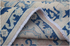 A handmade Afghan Kazakh rug featuring a traditional blue and cream geometric pattern.
