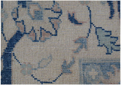 A close-up of a handmade Afghan Kazakh rug featuring traditional floral patterns in blue and beige.