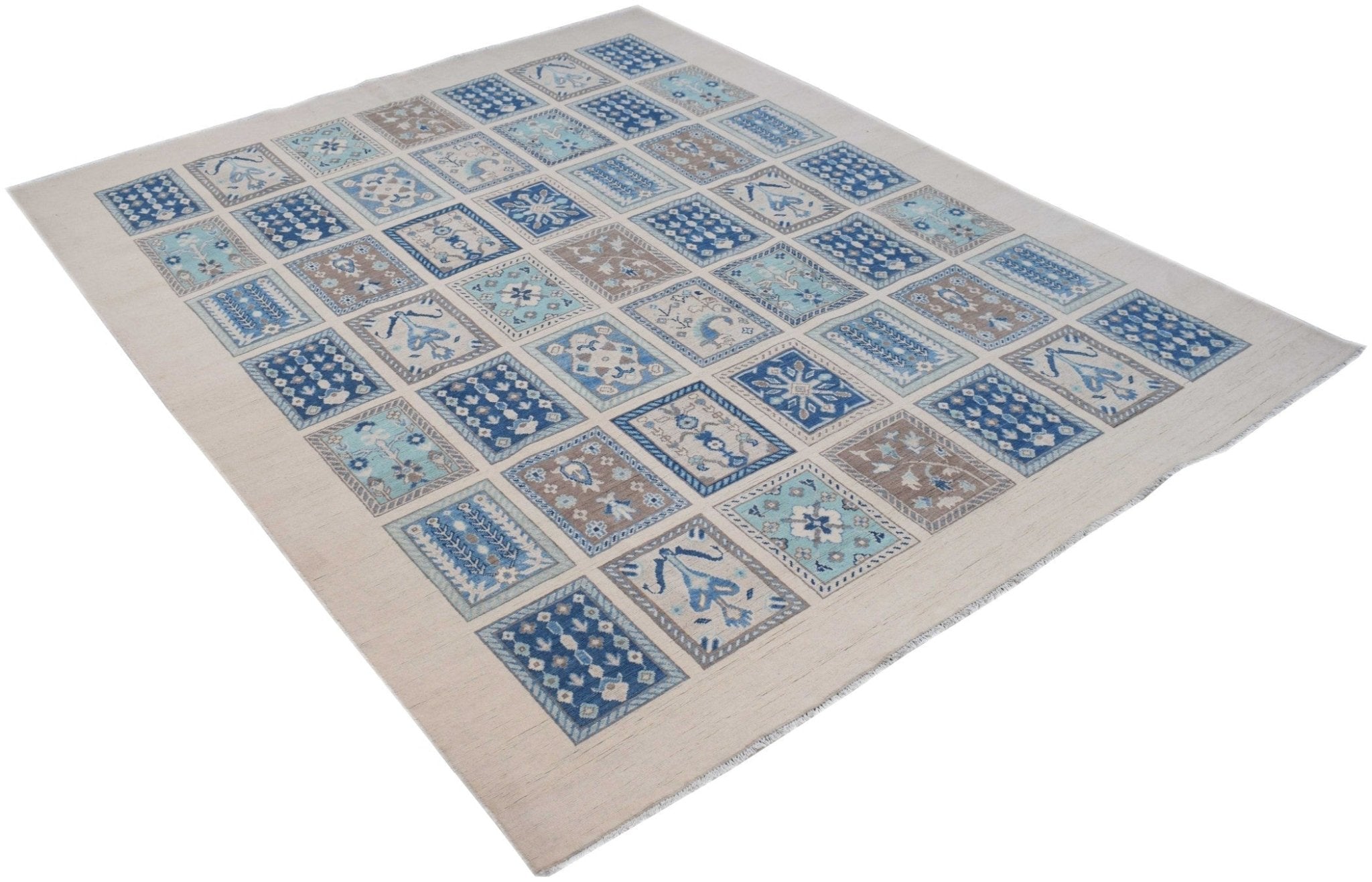 Handmade Afghan Kazakh rug featuring a grid of blue and beige geometric floral patterns.