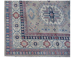 Handmade Afghan Kazakh rug featuring traditional geometric motifs in blue, red, and cream wool.