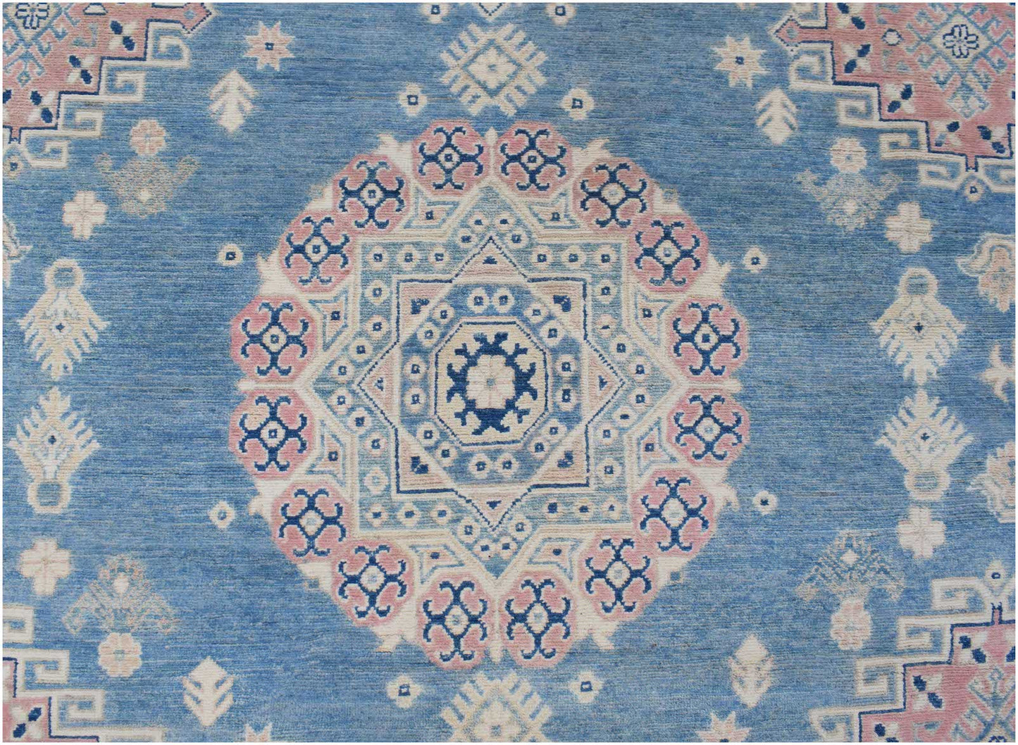 Handmade Afghan Kazakh rug featuring a central geometric medallion in blue, pink, and cream.