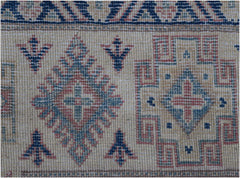 A handmade Afghan Kazakh rug featuring traditional geometric motifs in blue, red, and beige.