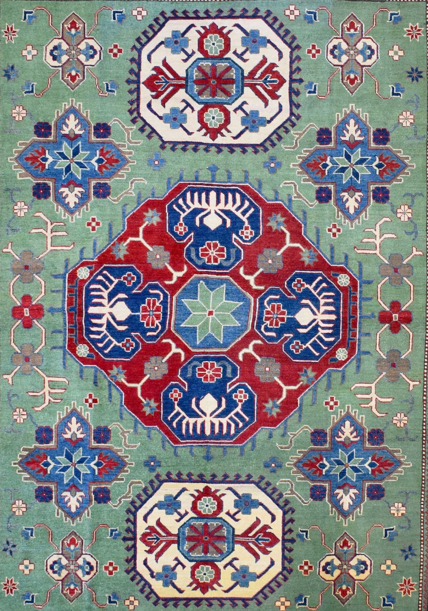 Handmade Afghan Kazakh rug featuring a geometric medallion pattern in red, blue, and green wool.