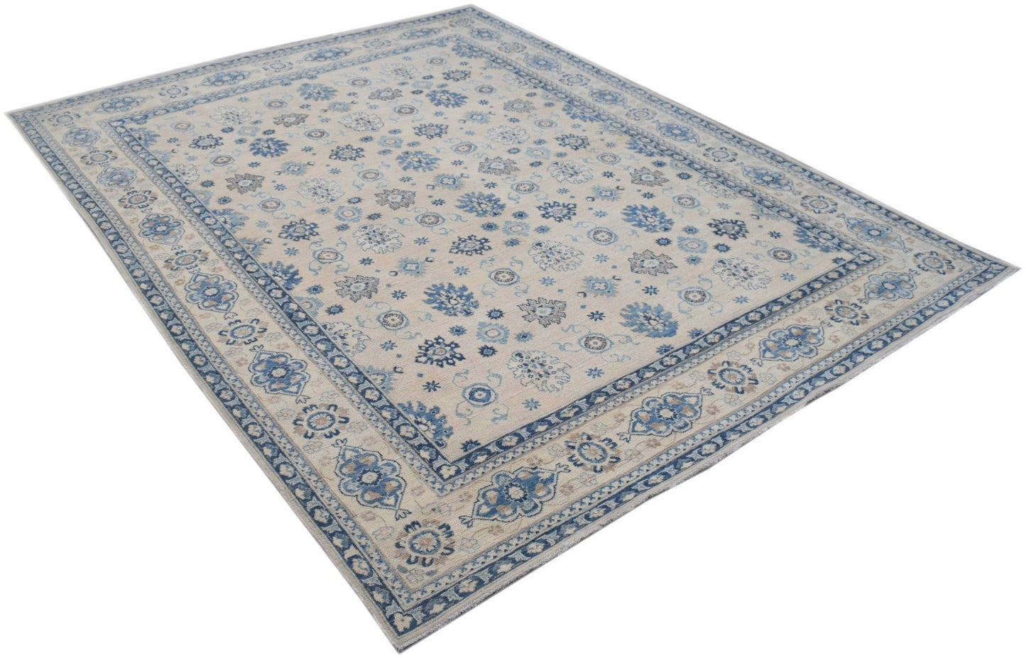 A handmade Afghan Kazakh rug featuring a beige field with blue and grey floral patterns.