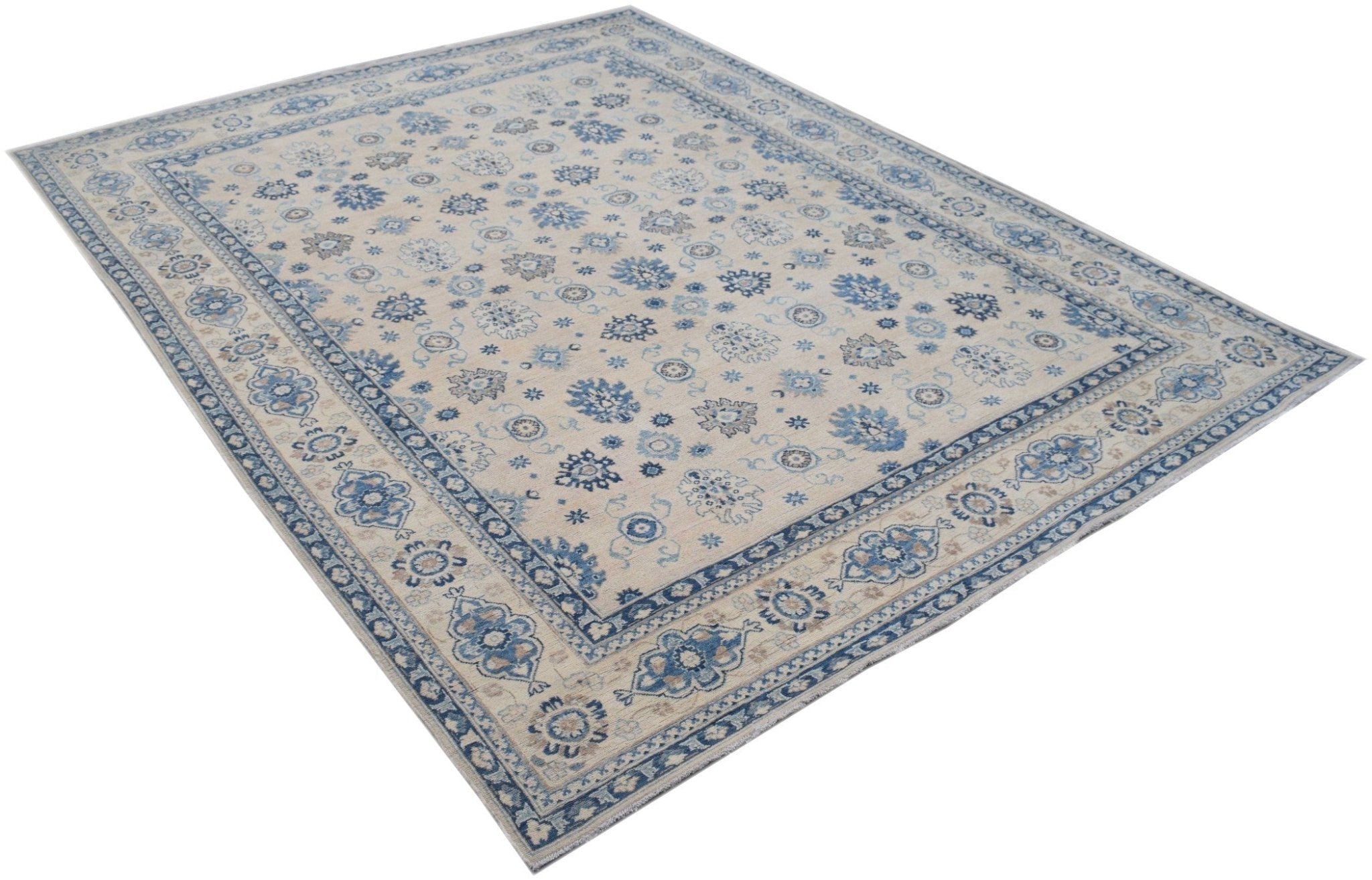 A handmade Afghan Kazakh rug featuring a beige field with blue and grey floral patterns.