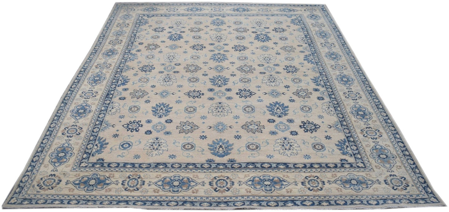 Handmade Afghan Kazakh rug featuring a beige field with blue and grey floral motifs.