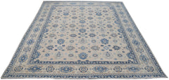 Handmade Afghan Kazakh rug featuring a beige field with blue and grey floral motifs.
