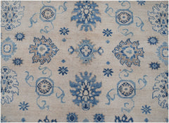 Handmade Afghan Kazakh rug featuring a beige background with blue and grey floral motifs.