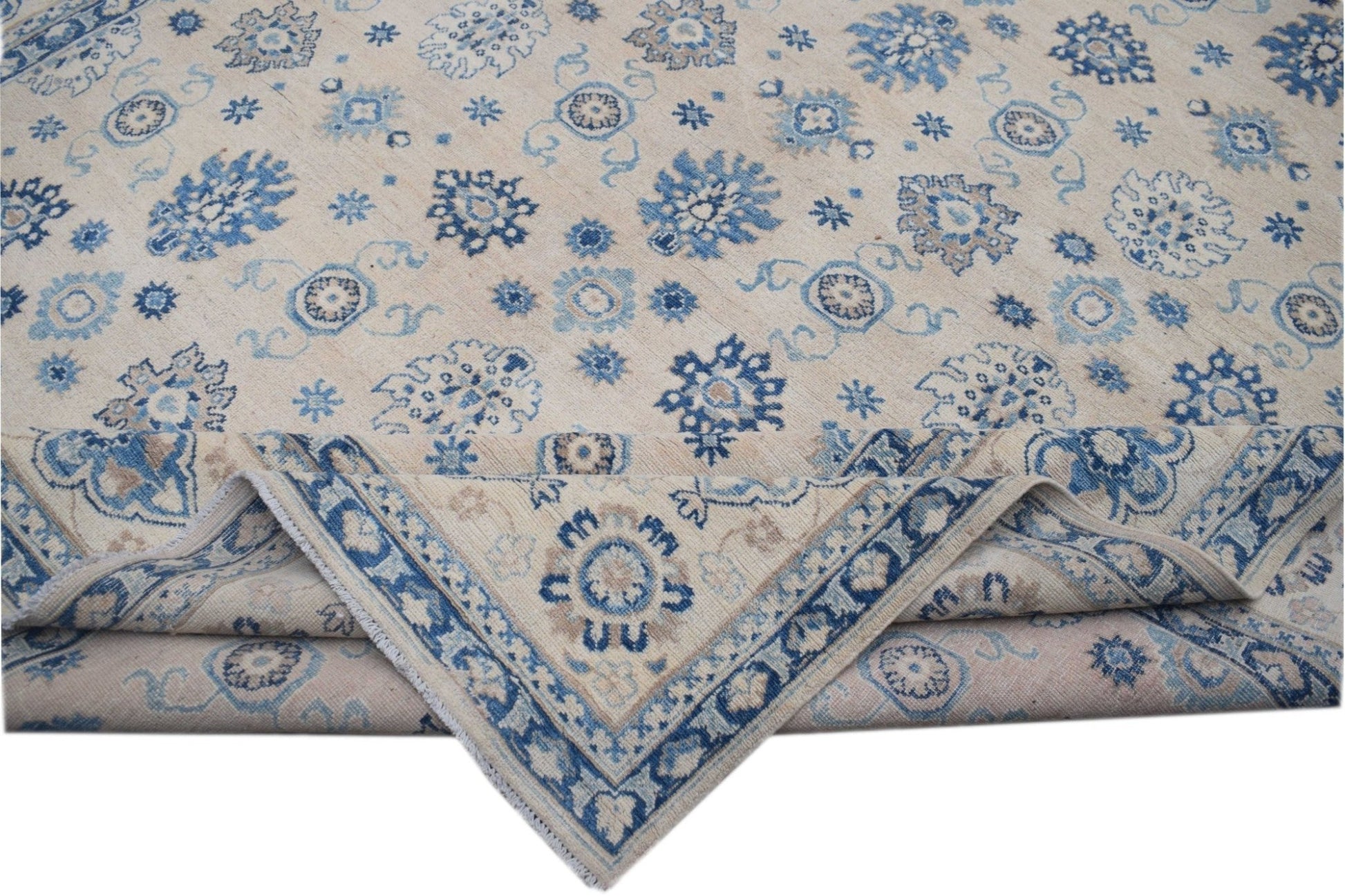 Handmade Afghan Kazakh wool rug featuring a beige field with blue and grey floral motifs.