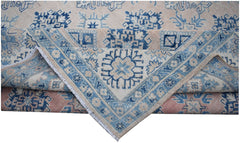 An Afghan Kazakh rug featuring traditional blue geometric patterns on a light beige wool background.