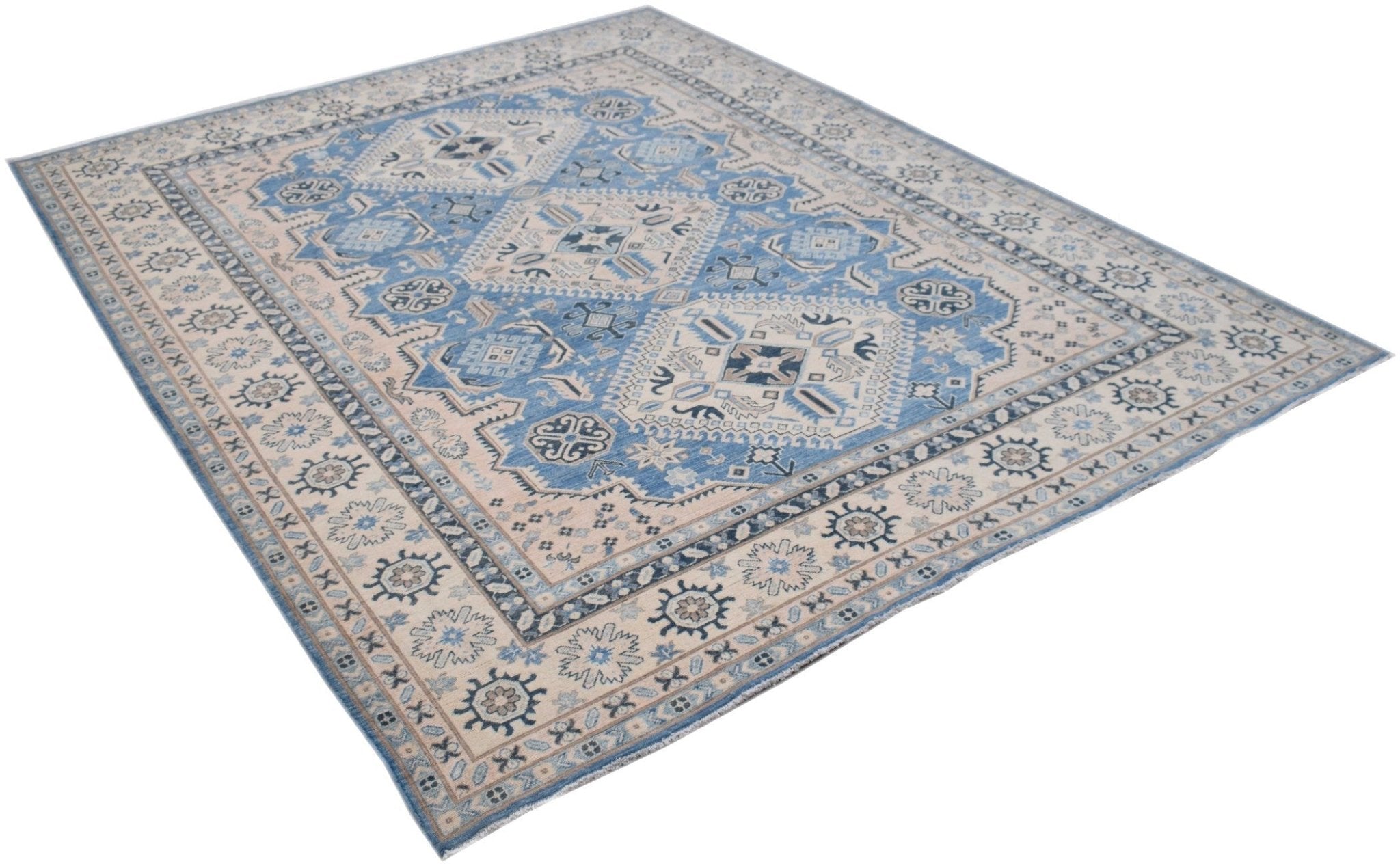 A handmade Afghan Kazakh rug featuring a geometric pattern in shades of blue, beige, and grey.
