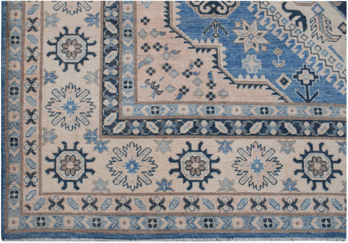 Handmade Afghan Kazakh rug featuring a geometric floral pattern in shades of blue, beige, and grey.