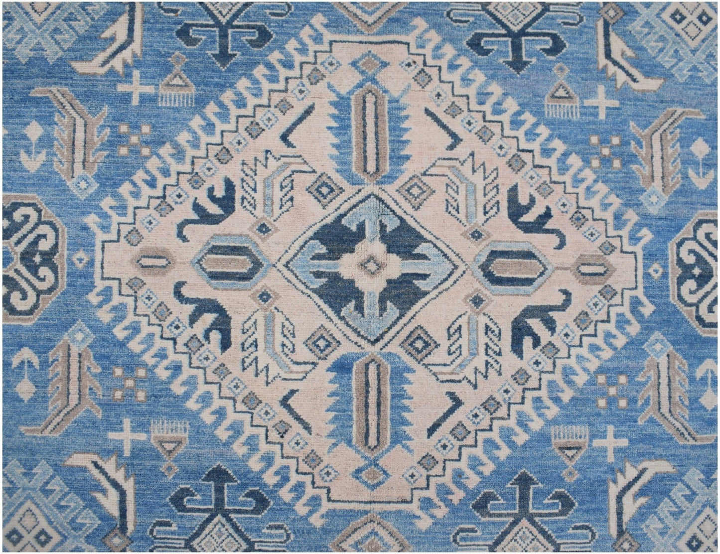 Handmade Afghan Kazakh rug featuring a geometric diamond pattern in shades of blue, beige, and grey.