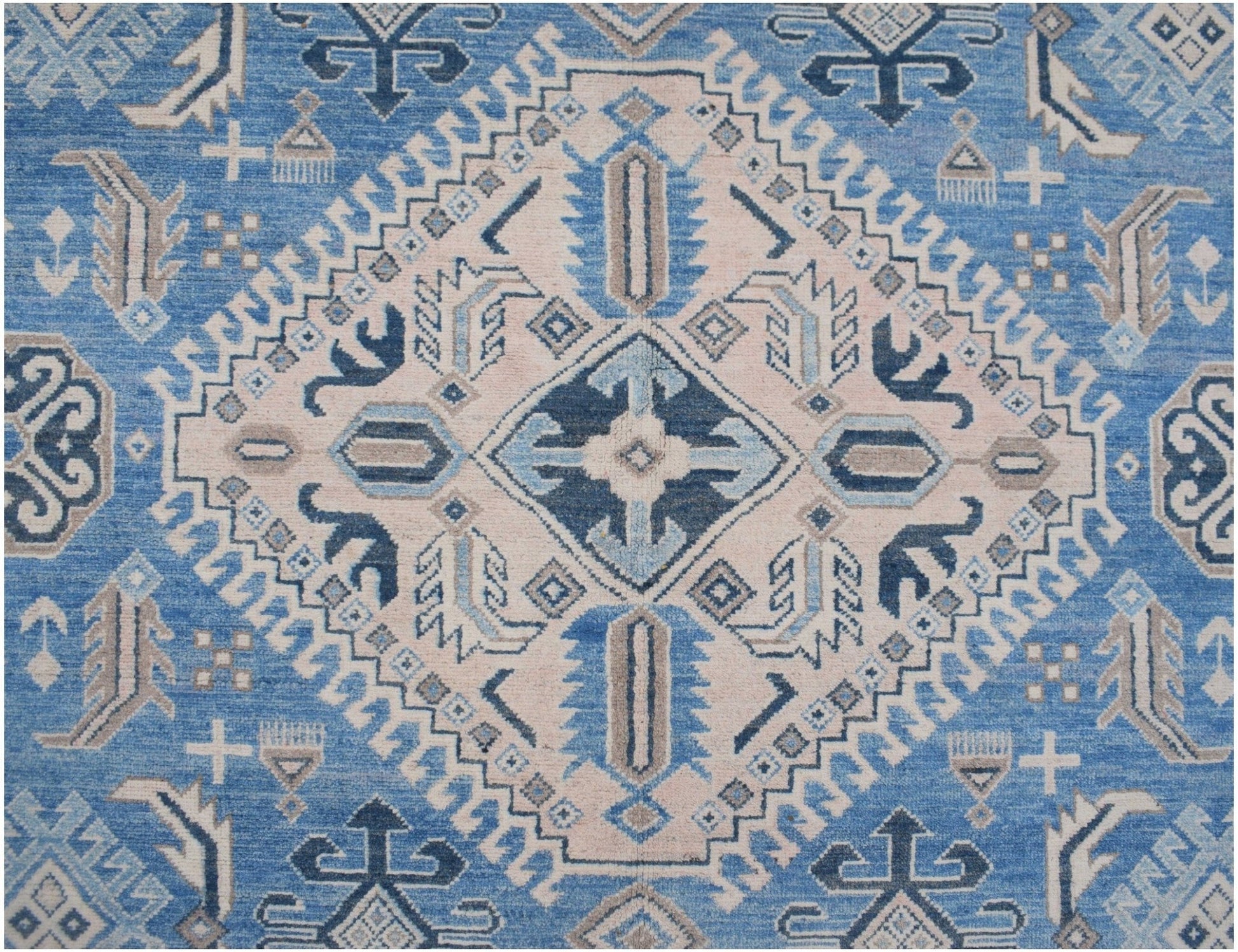 Handmade Afghan Kazakh rug featuring a geometric diamond pattern in shades of blue, beige, and grey.