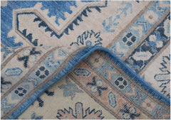 A handmade Afghan Kazakh rug featuring a geometric pattern in shades of blue, beige, and grey.